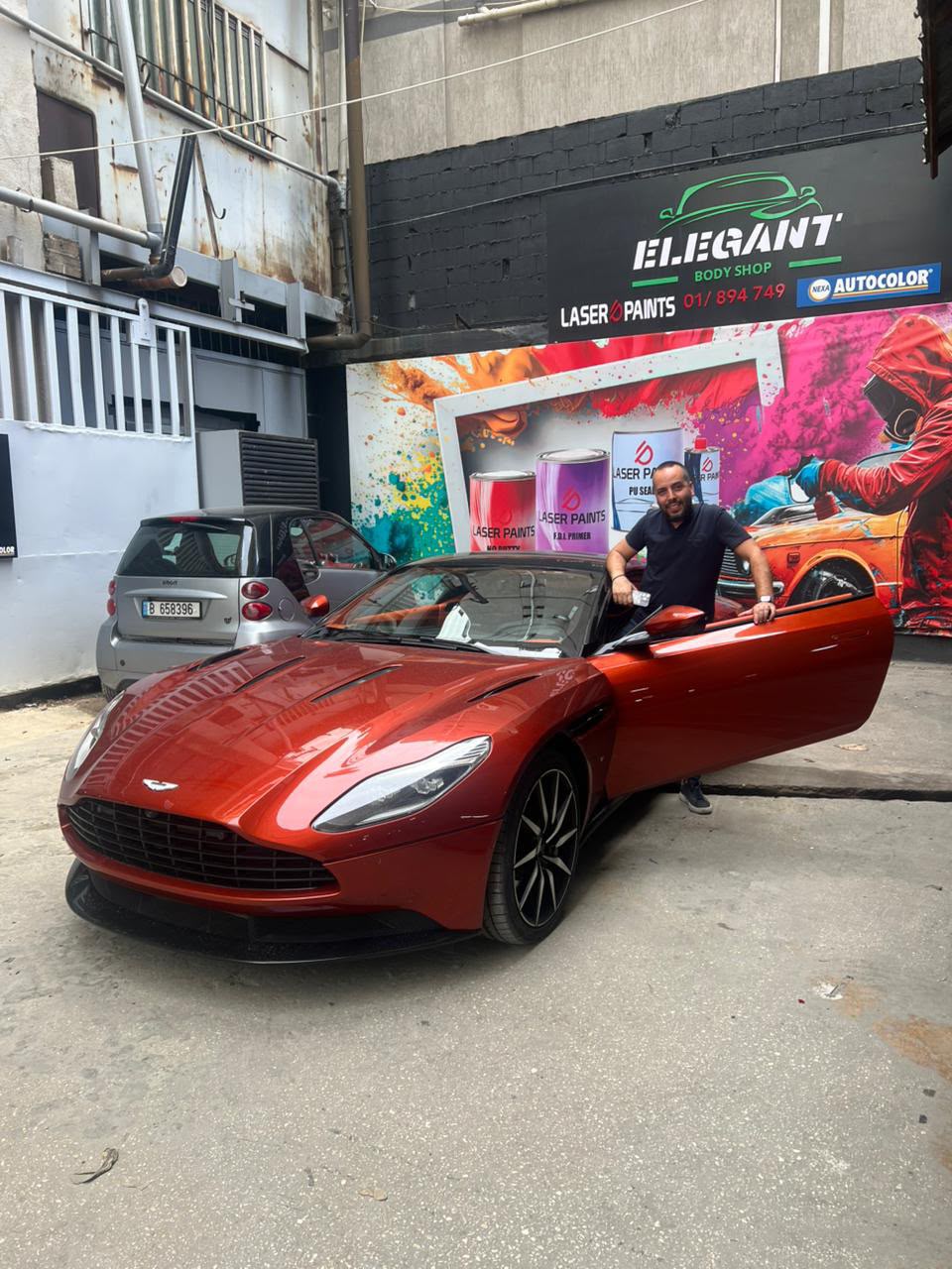 Raffi Halvadjian beside an orange Aston Martin convertible